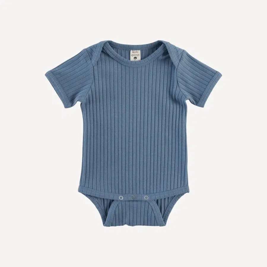 A blue ribbed t-shirt onesie from Kate Quinn. 