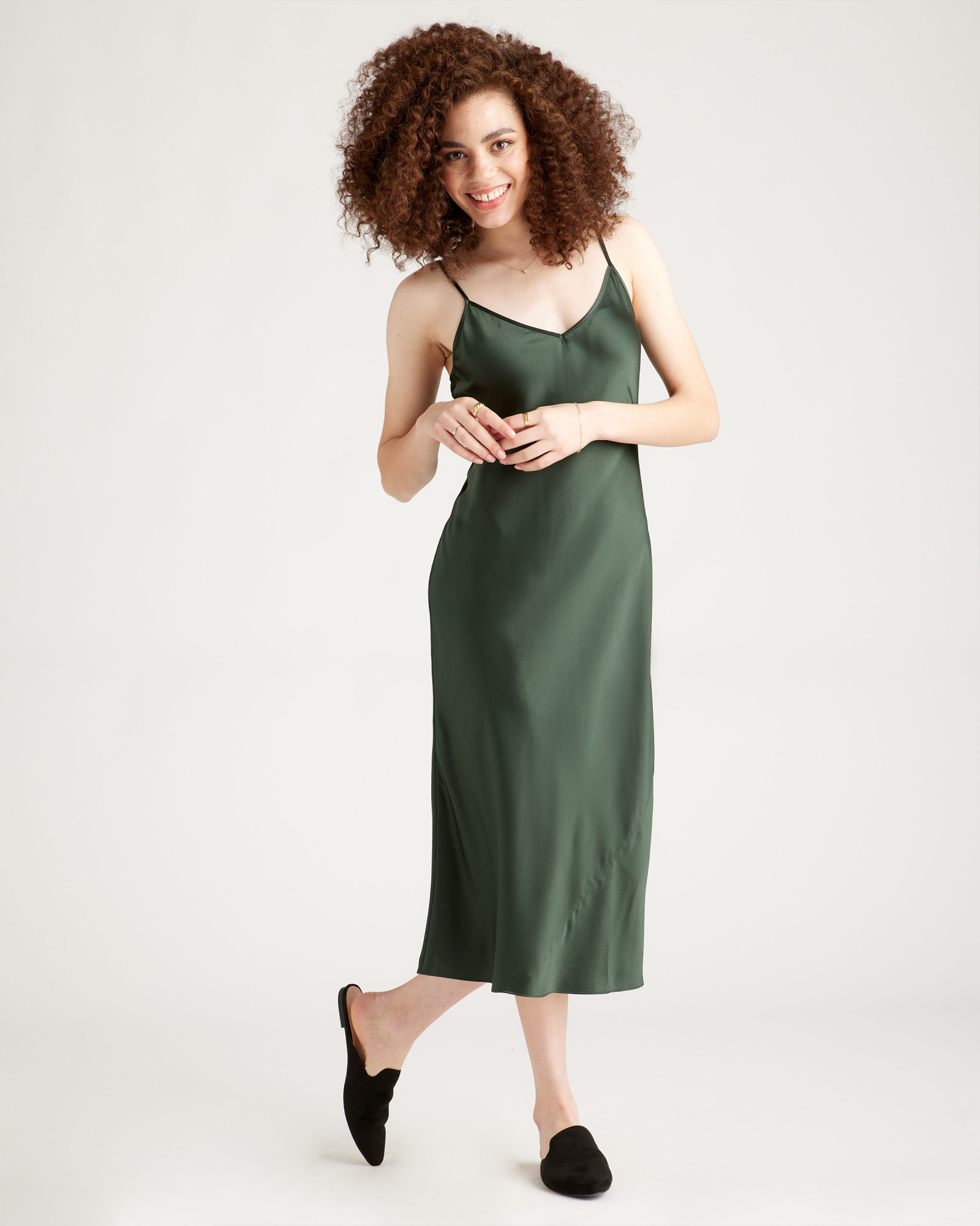 A model wears a forest green slip dress.