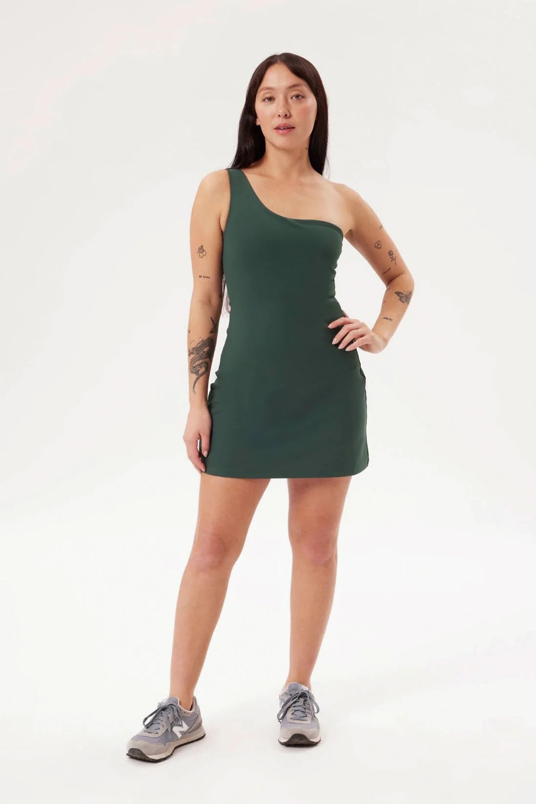 A model in a one shouldered workout dress in green.