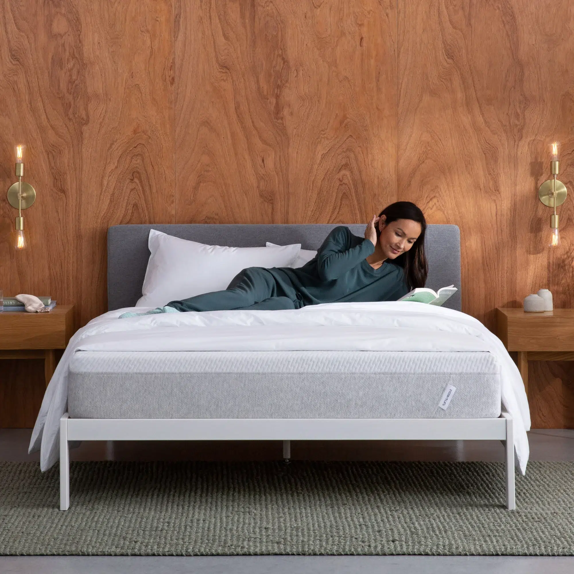 A model lounges and reads on an eco-friendly foam mattress. 