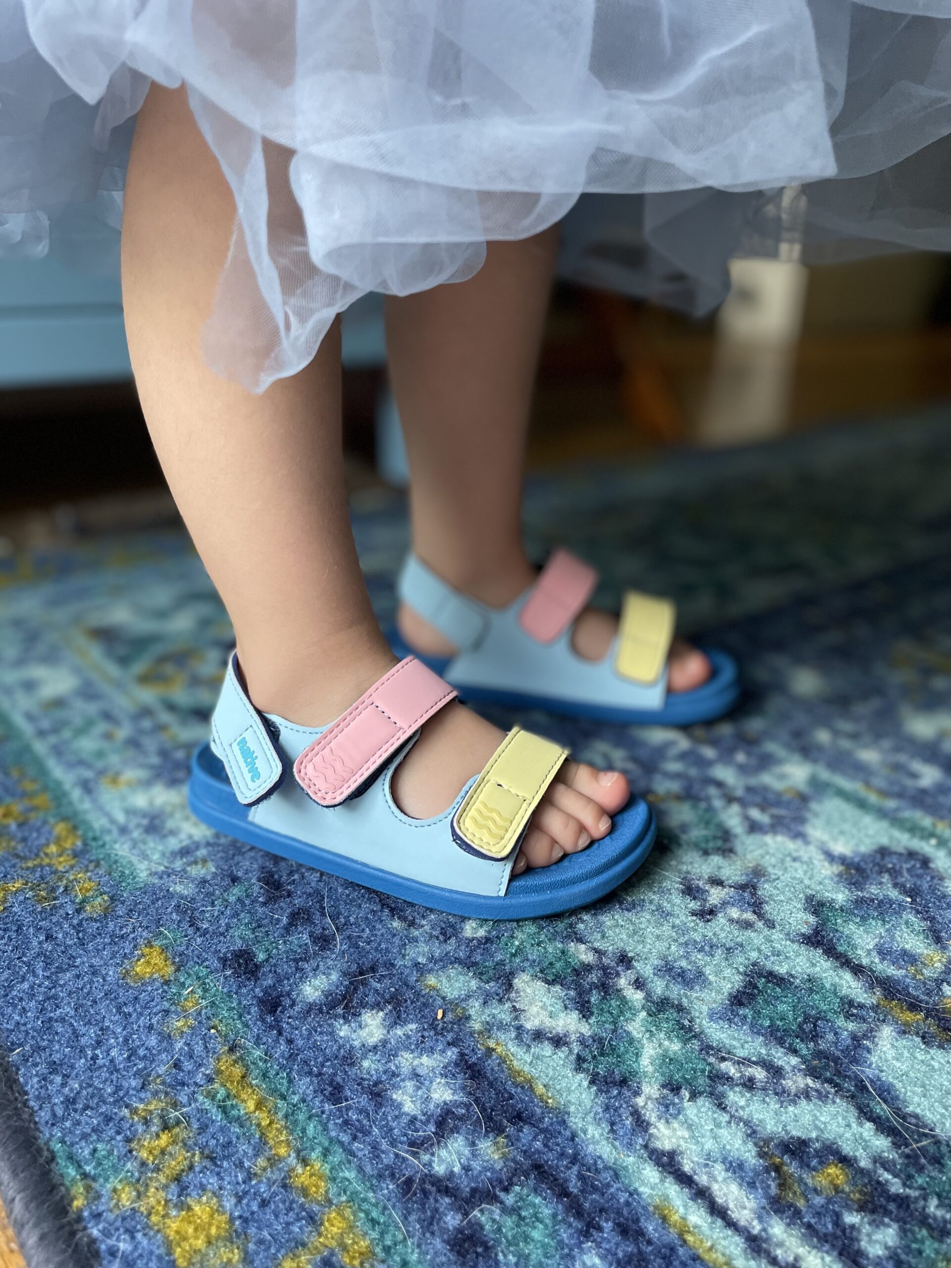 A little girl's feet in Native sandals.