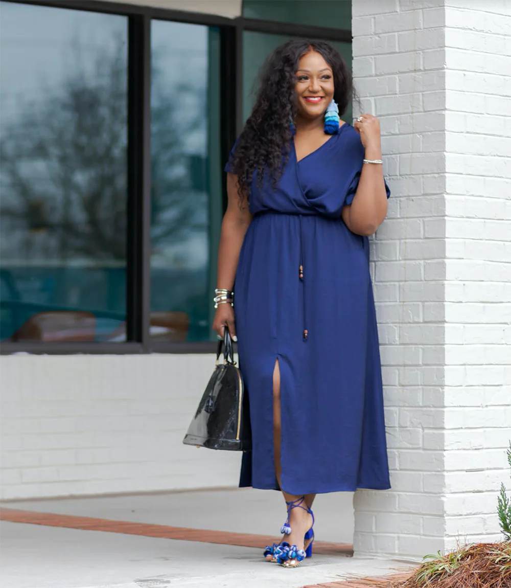 A plus size model in a navy blue dress. 