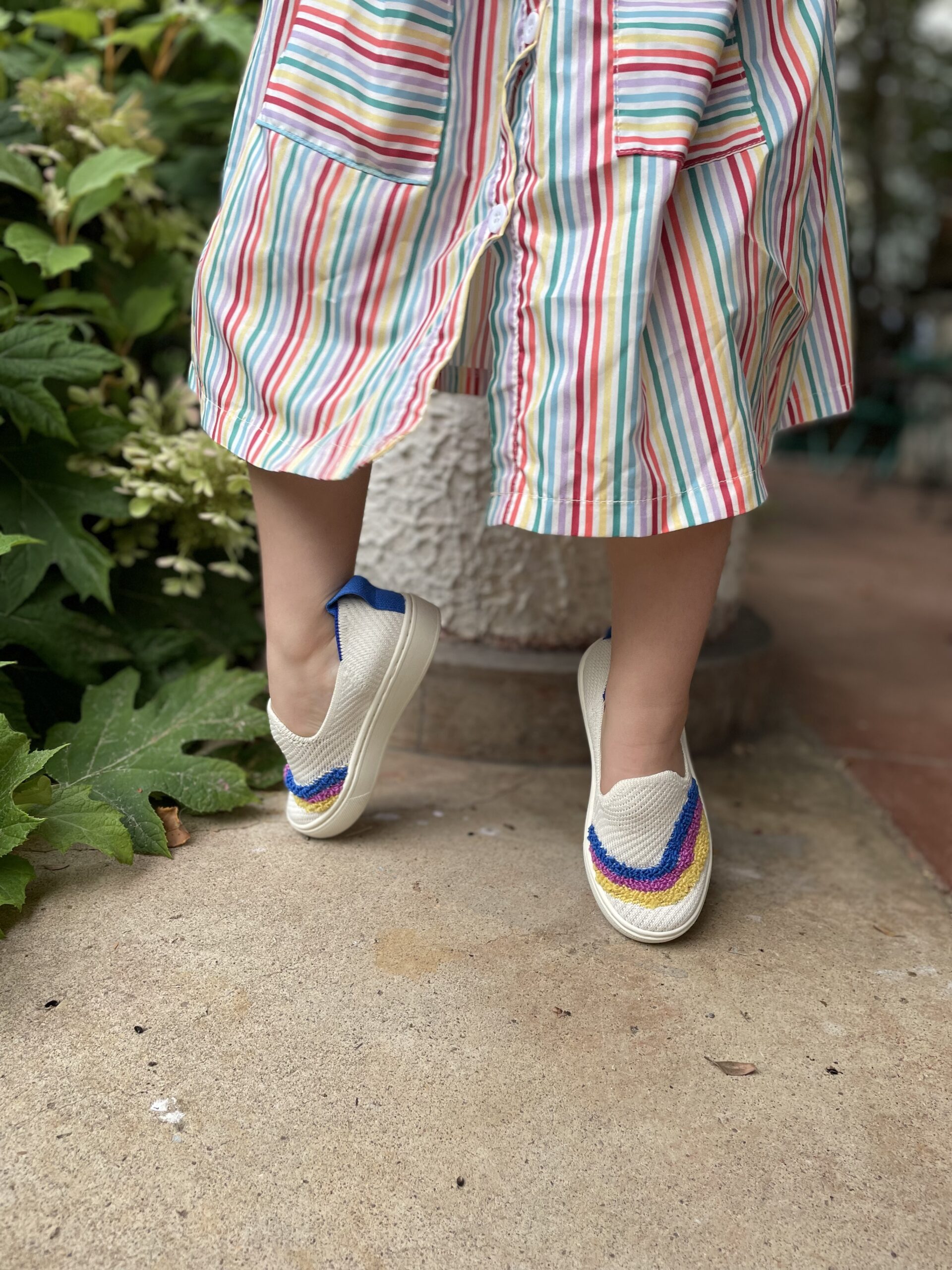 A little girl's feet on tippy toes wearing Rothys.