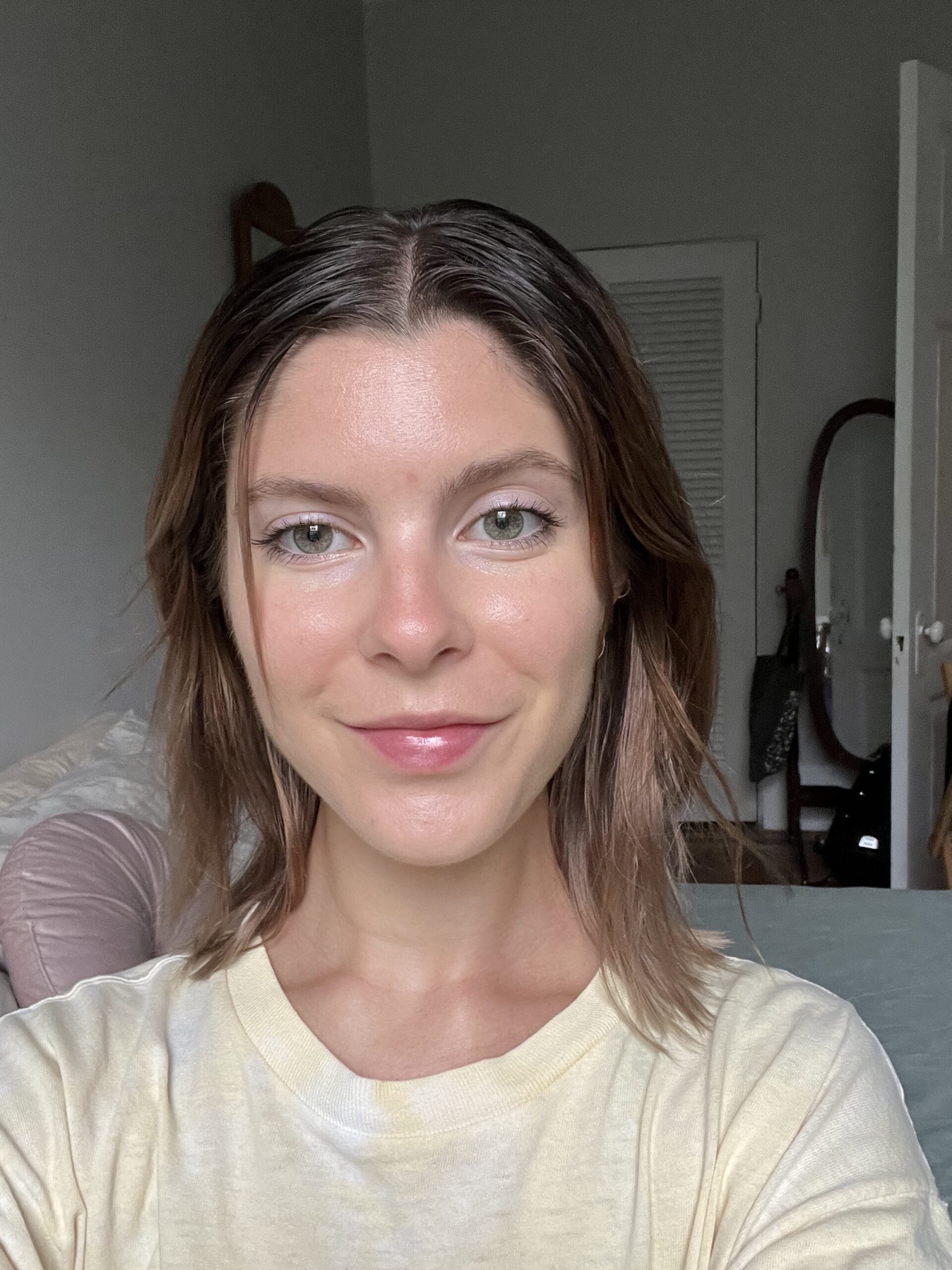 A woman smiles at the camera wearing Ilia foundation.