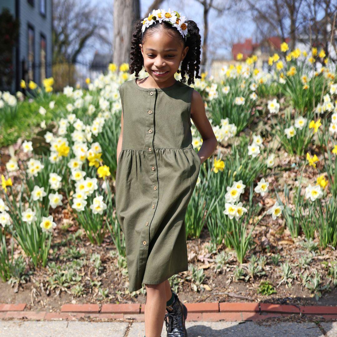 A girl wearing an olive button down dress.