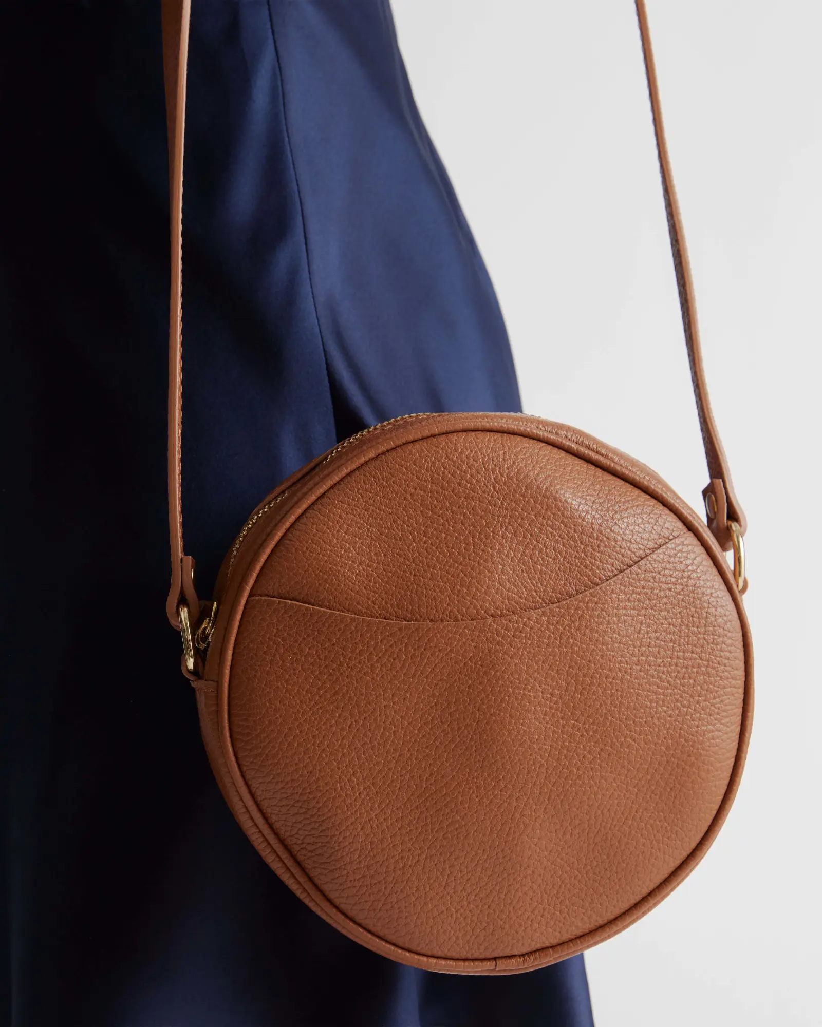 A round brown leather bag. 