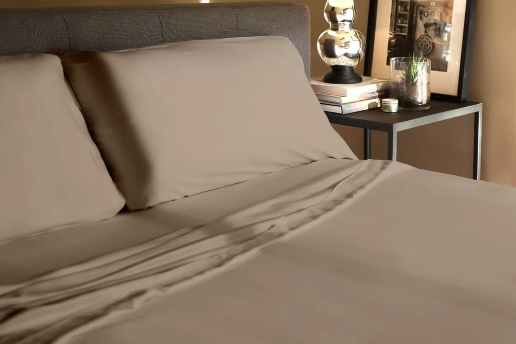 A bed made up in tan Tencel sheets. 