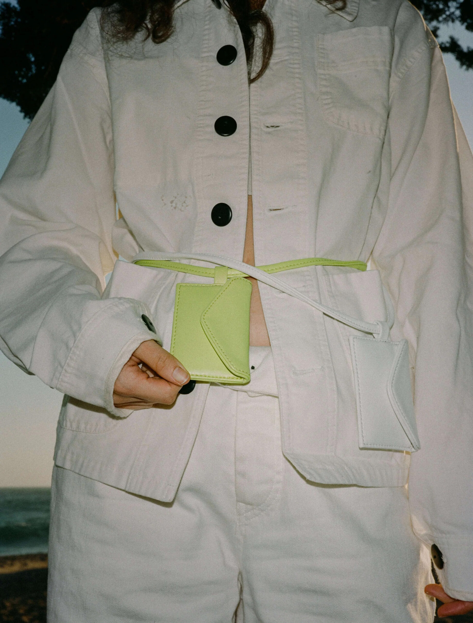A lime green card carrying sling on a model's waist. 