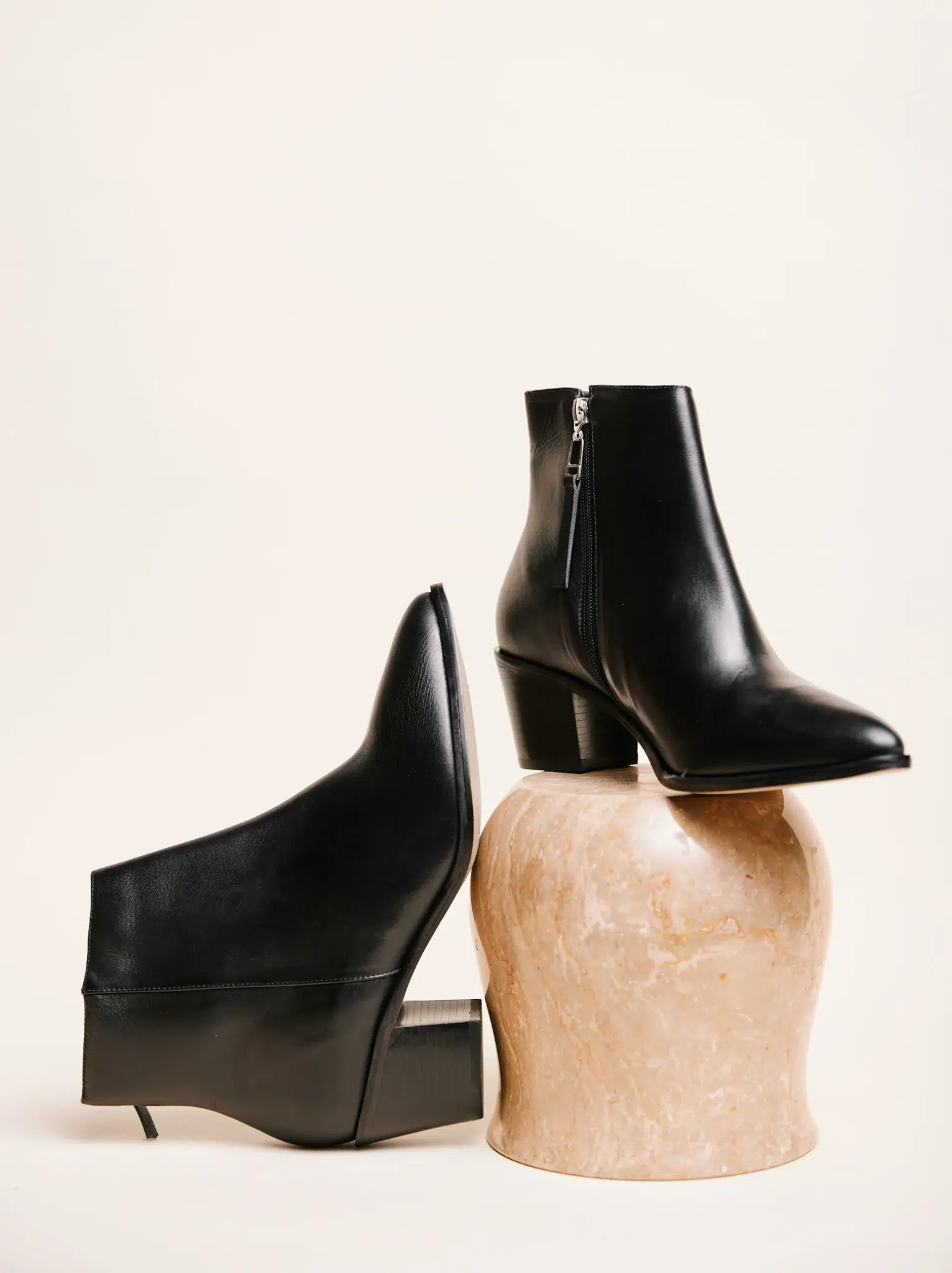 A pair of black leather ABLE sustainable ankle boots. 