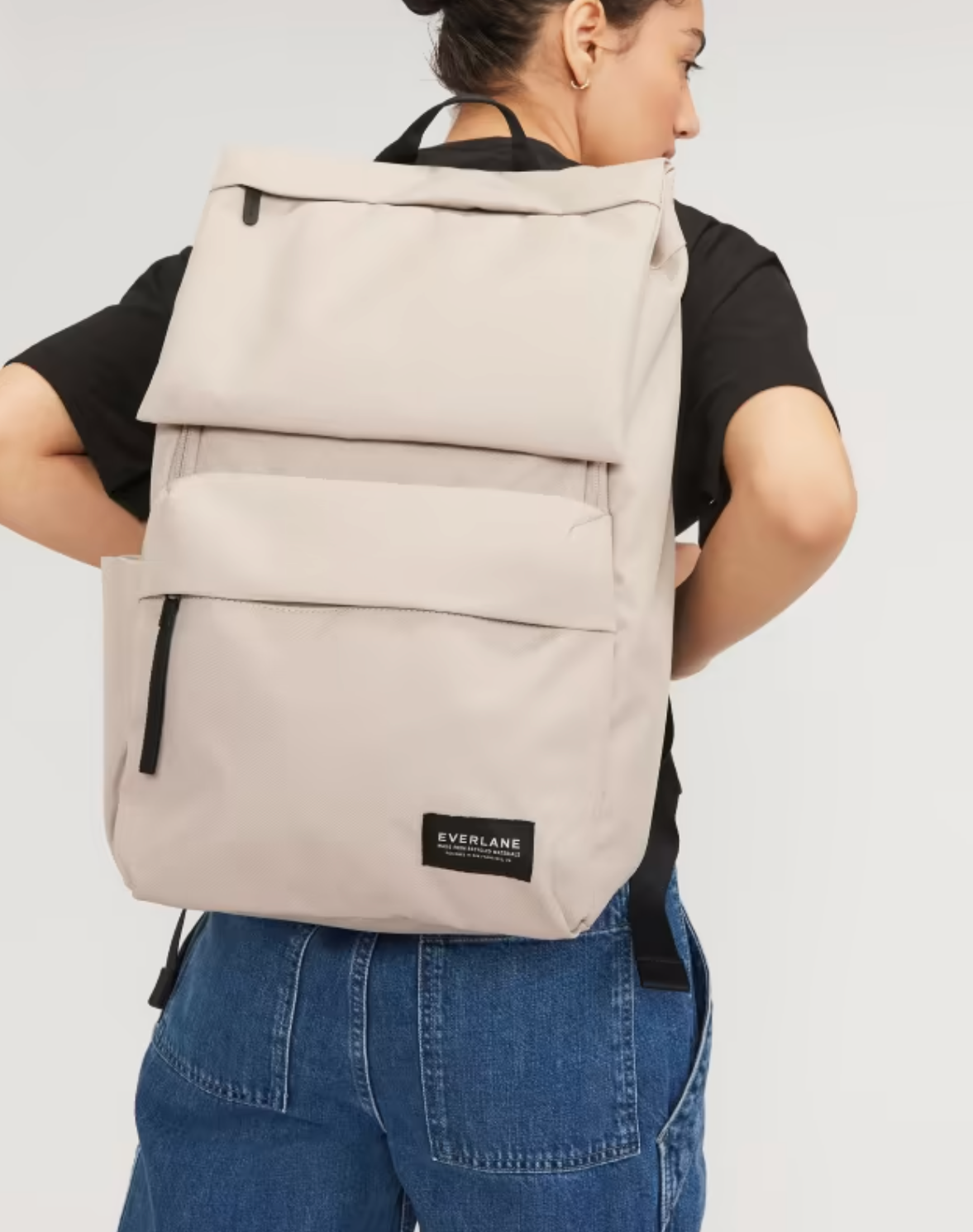 A model wears the Everlane ReNew Transit Backpack on her back. 