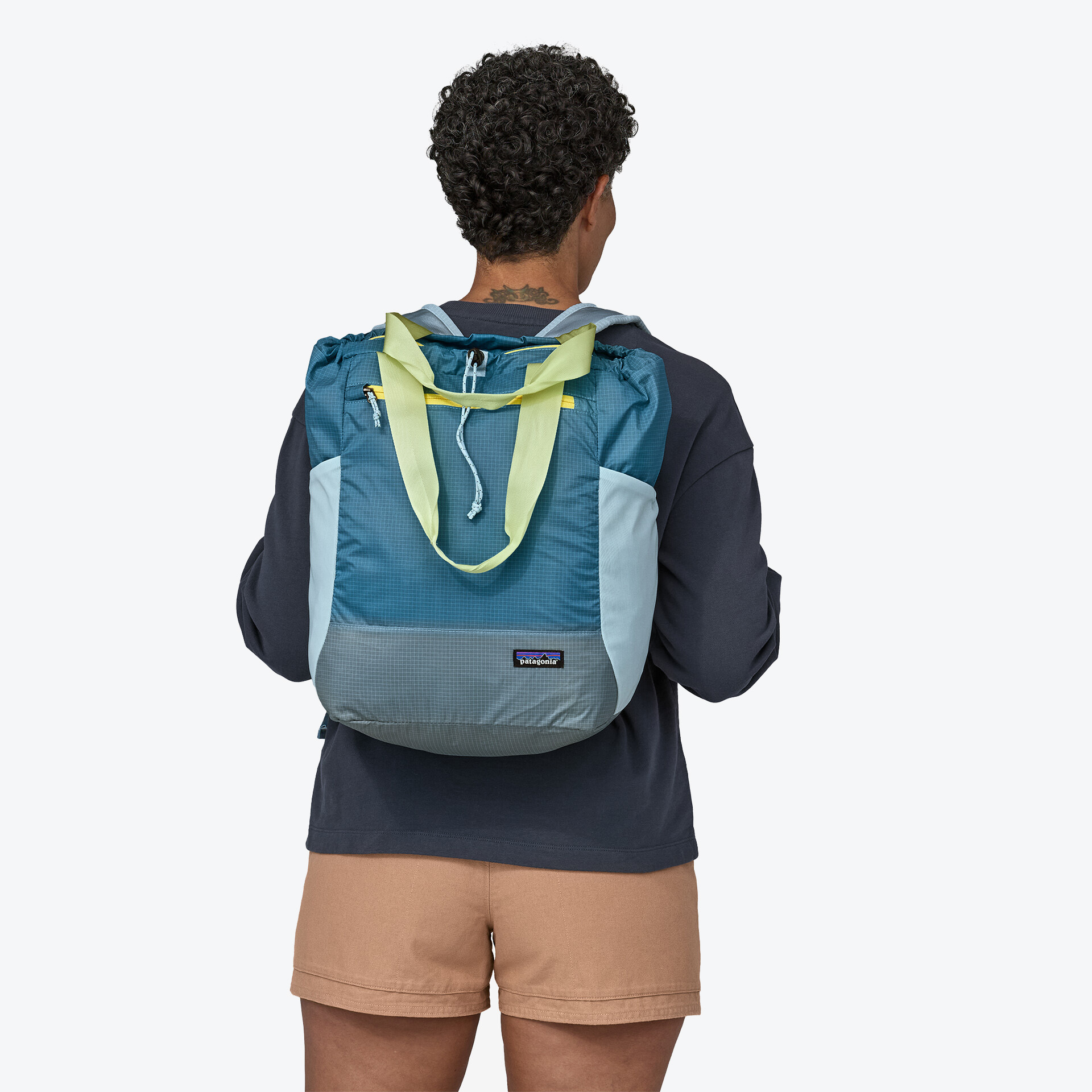 A model wearing the Patagonia Ultimate Black Hole Tote as a backpack.