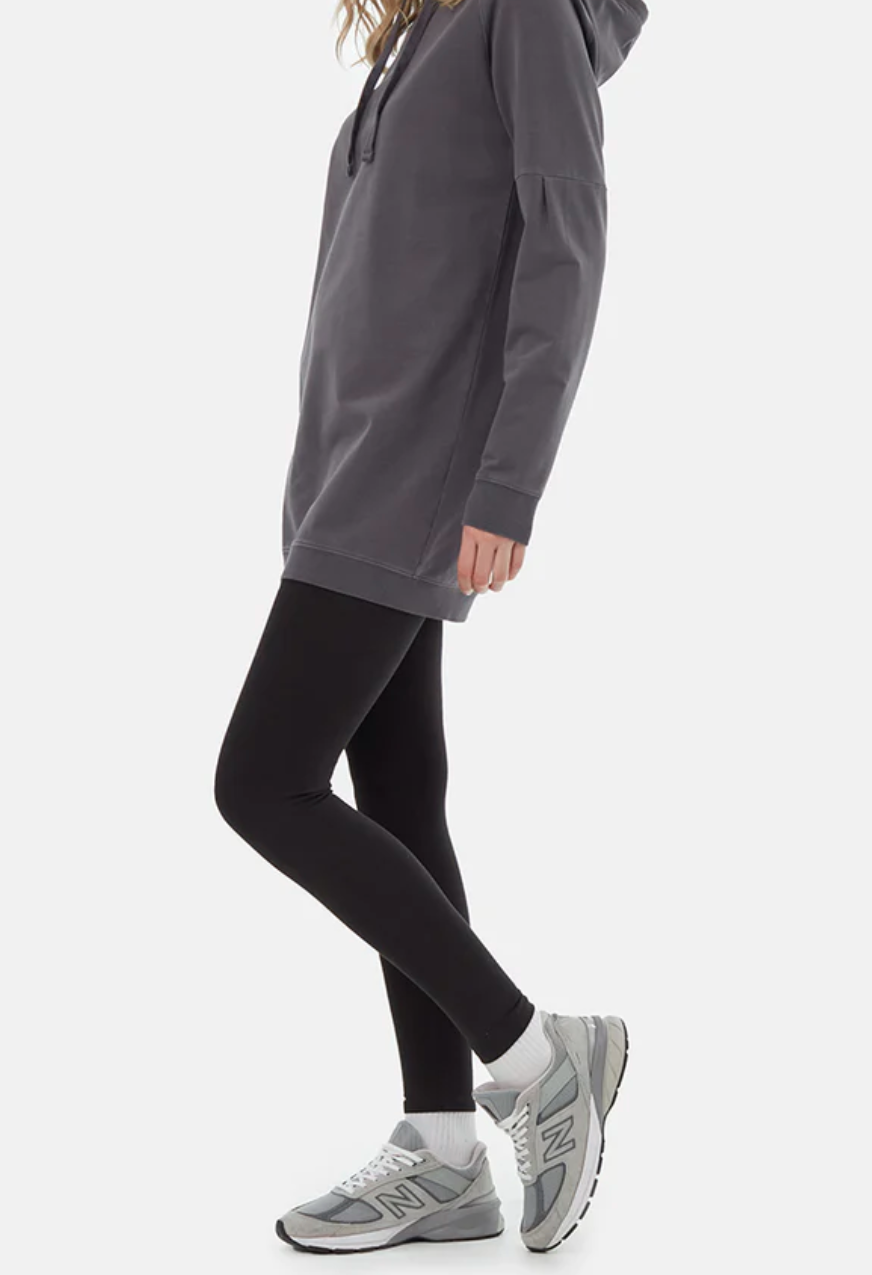 A model's body in an oversized gray hoodie and black cotton leggings.