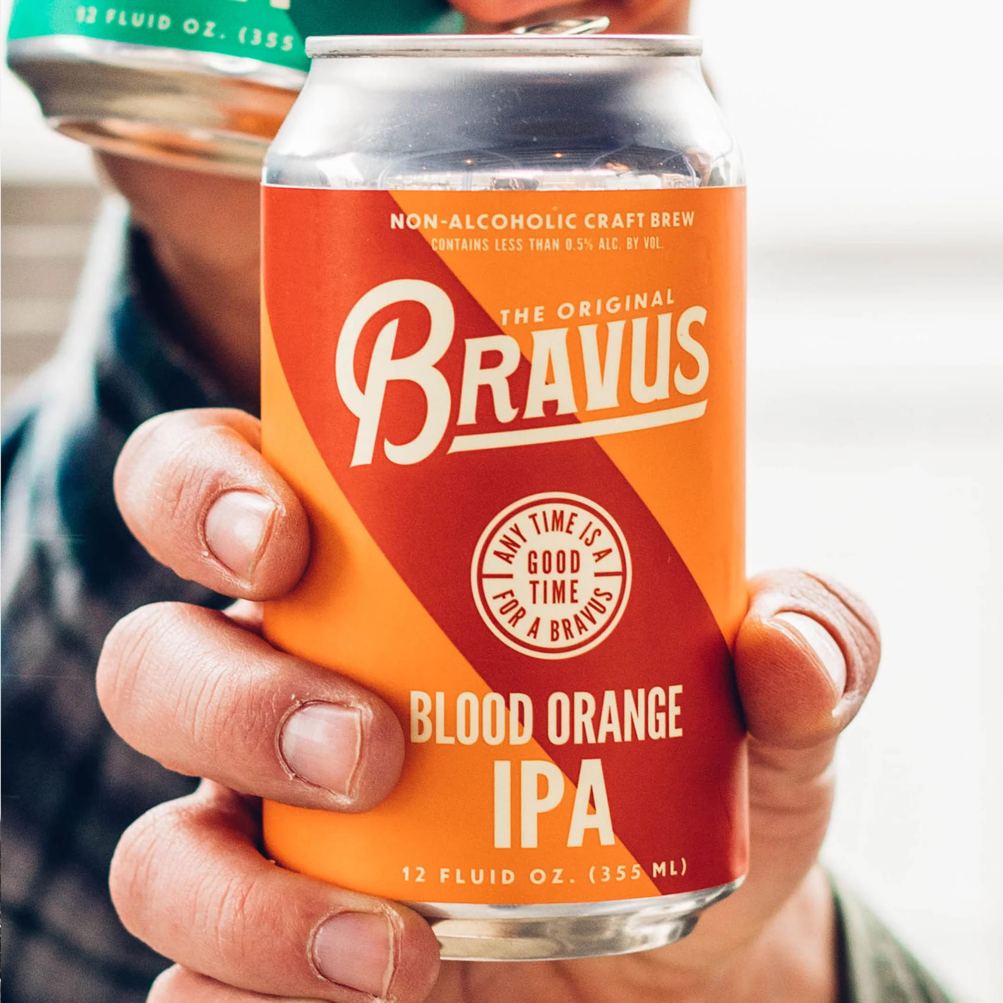 A close up of a hand holding a can of Bravus Blood Orange IPA.