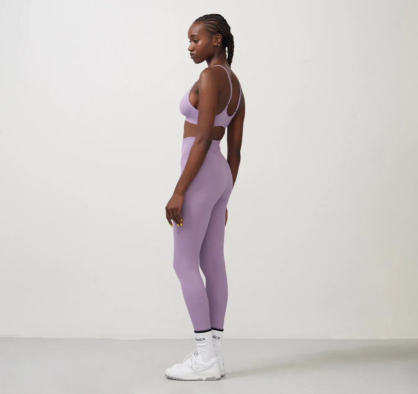A model wears a lavender sports bra and legging set. 