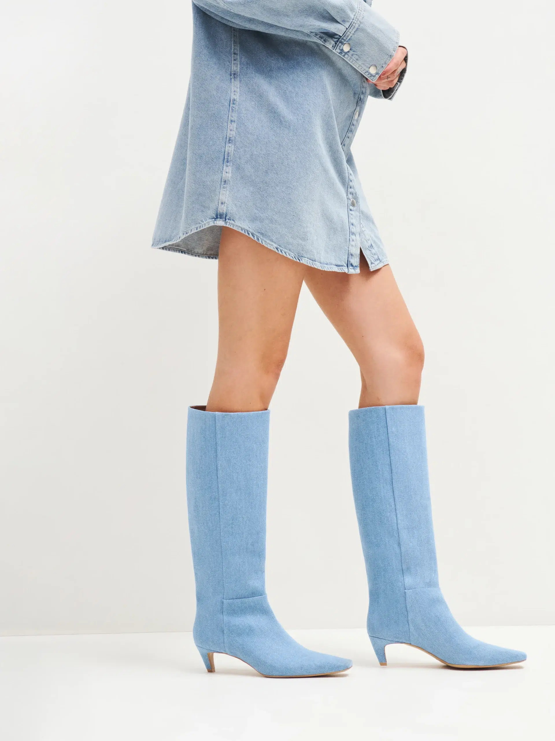 A model in denim Reformation boots. 