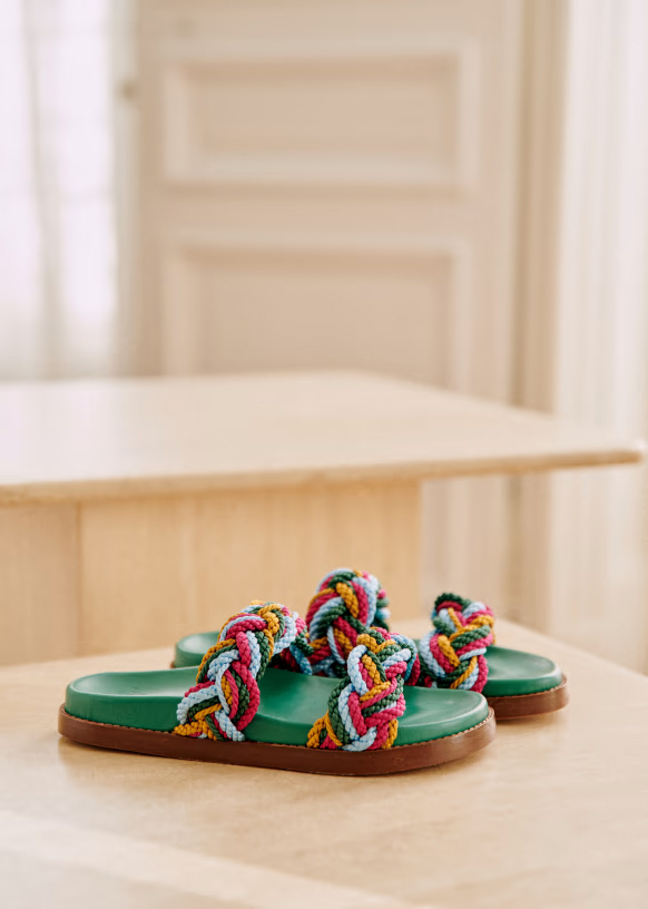A pair of green-footbed and multicolored braided strapped mule sandals. 