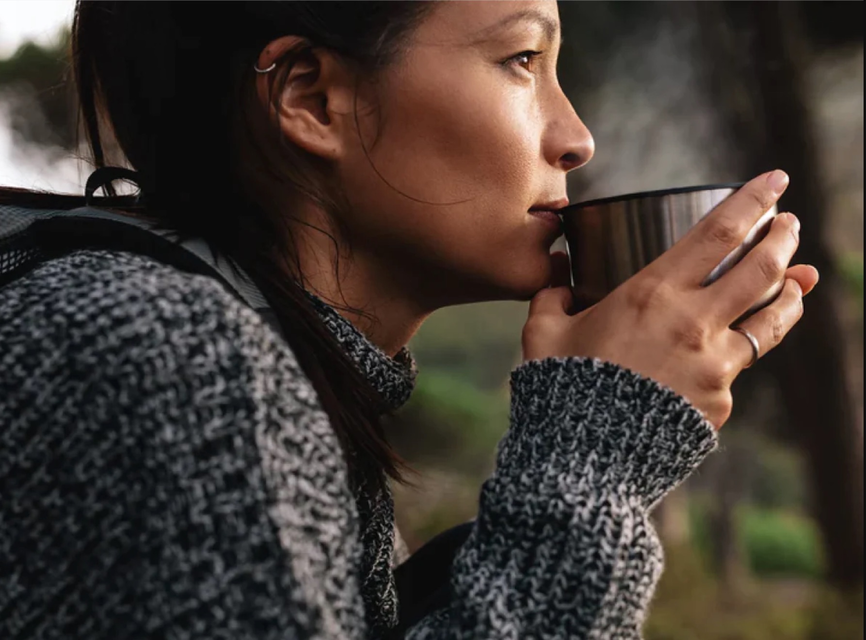 A model sips a mug of Fabula coffee.