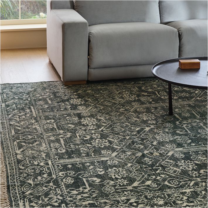 A detail of a patterned West Elm nontoxic rug in a styled living room.
