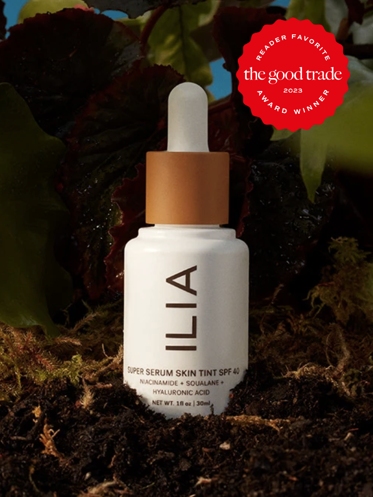 Ilia's skin-tint foundation on top of dirt with leaves behind. The Good Trade 2023 Reader Award Favorite Winner red sticker is on the top right of the image.