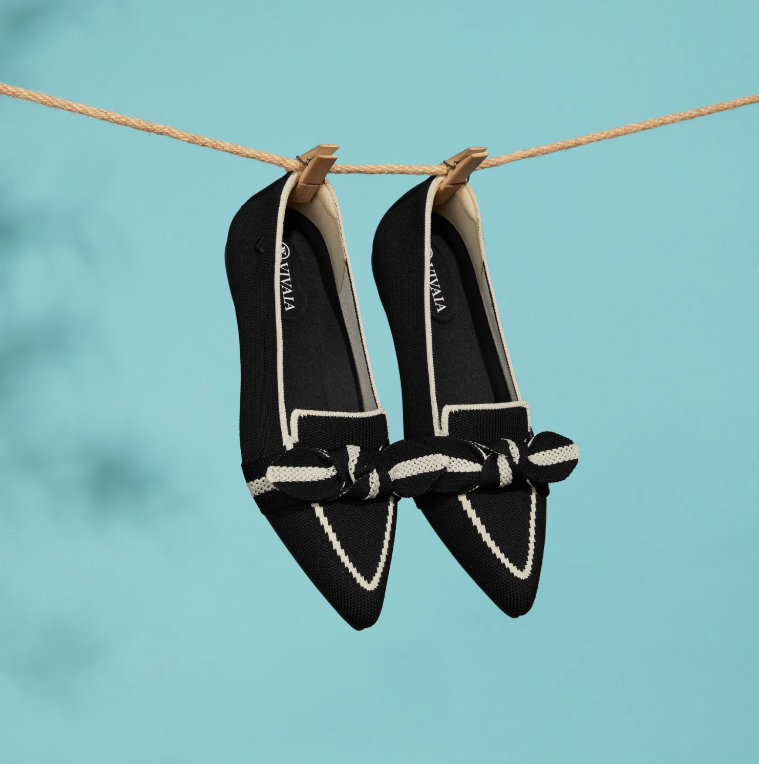 A pair of Vivaia sustainable loafers hanging on a clothesline.