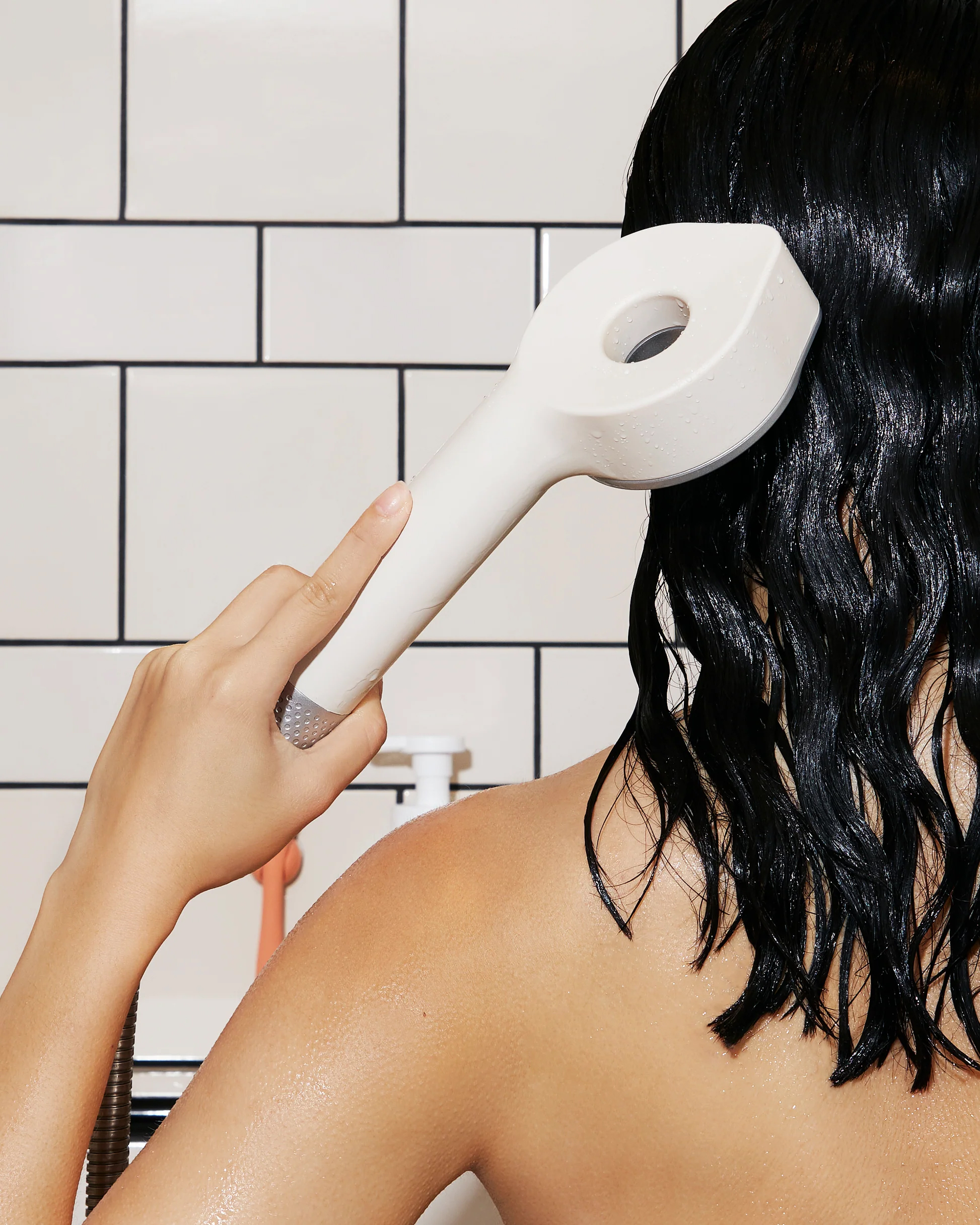 A model washing her hair with a Hello Klean filtered showerhead.