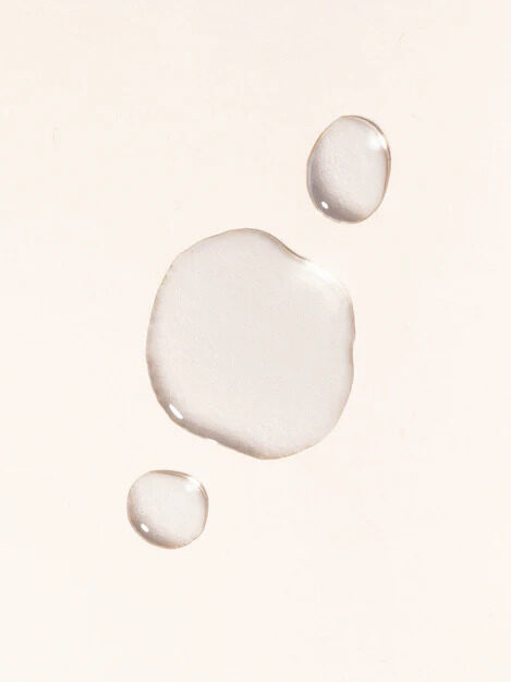 Drops of Makesy's Organic and Wildcrafted Witch Hazel Toner on top of a pale yellow background.