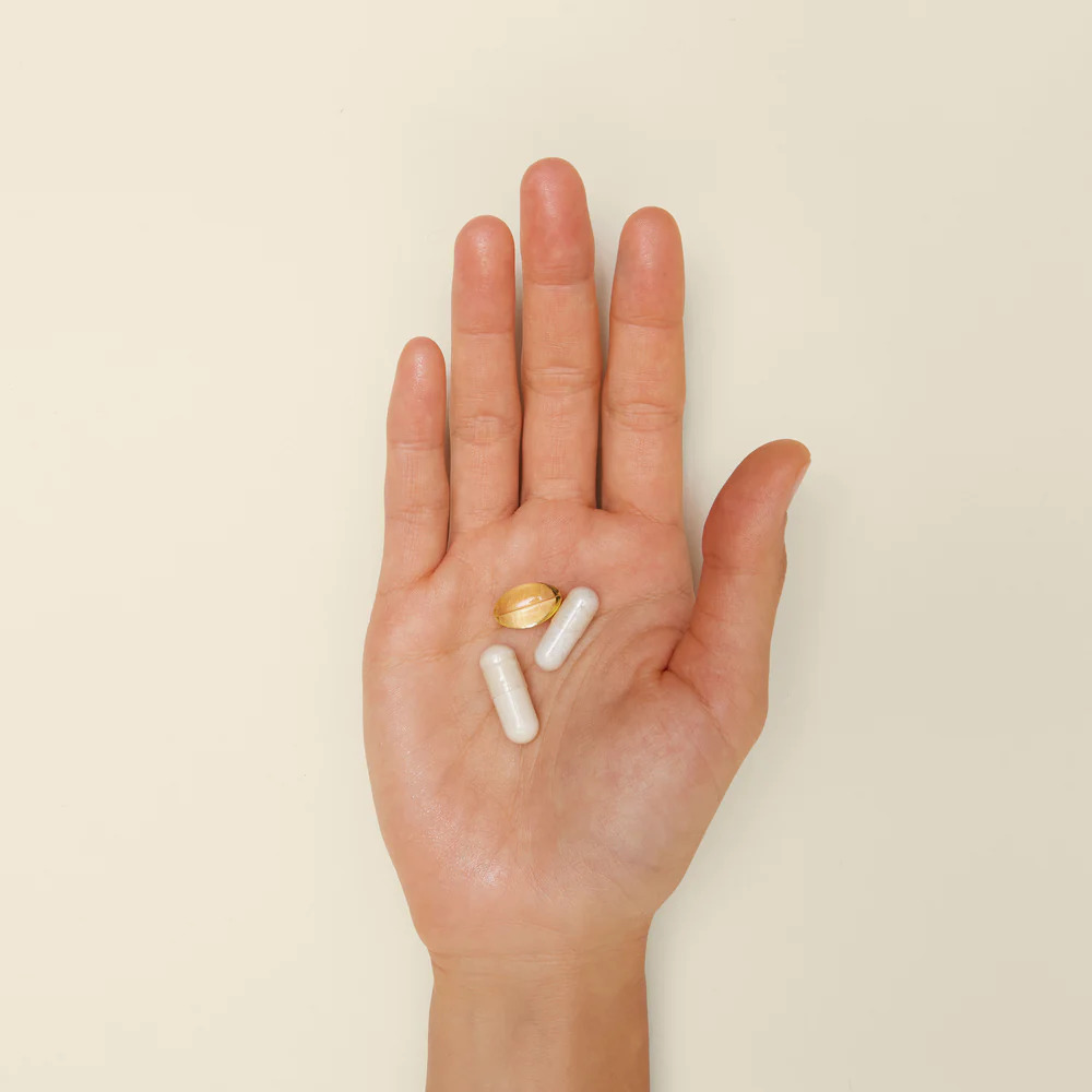 An open hand with 3 Perelel multivitamin supplements in the center.