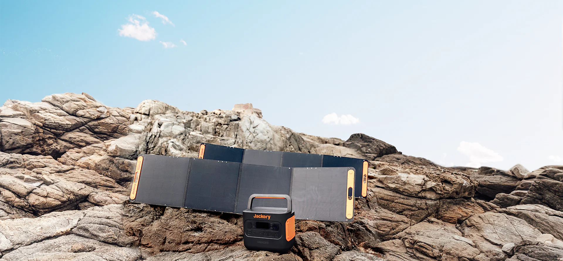 A Jackery solar generator sitting outside on some rocks. 