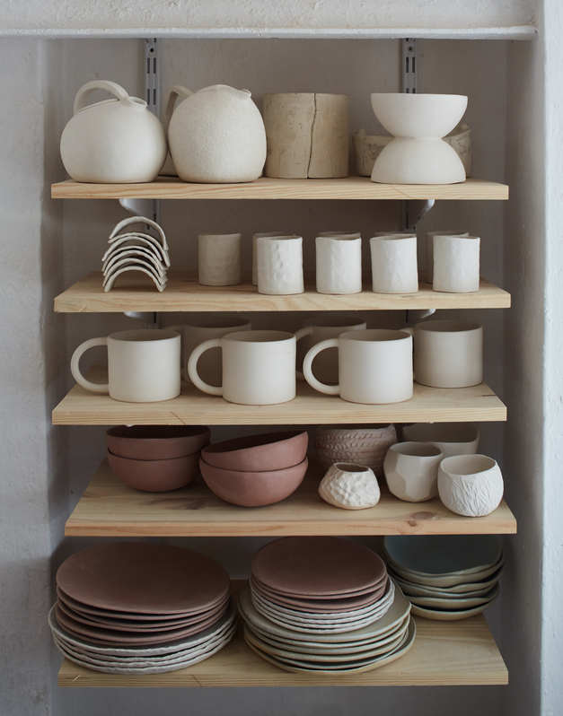 Atelier or studio corner with pottery and ceramics products on shelves