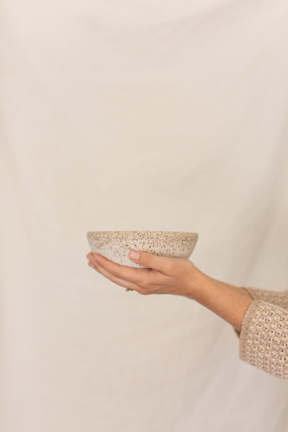Women's hands holding handmade ceramic bowl.