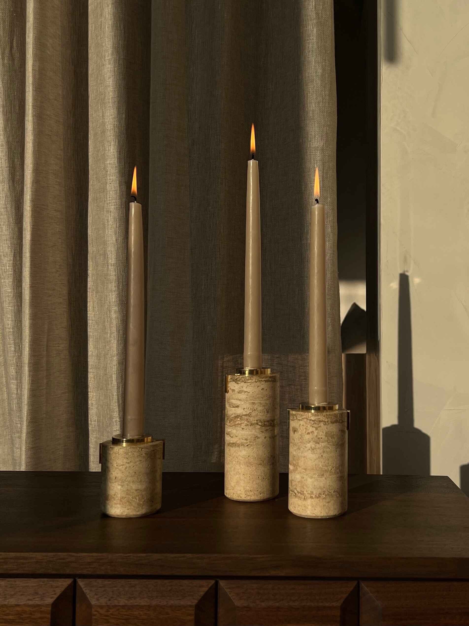 3 marble stone candle holders with grey lit candles in each, by Afternoon Light. 