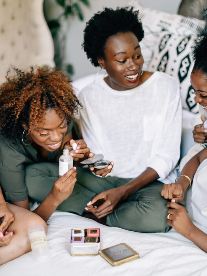 A group of women looking, touching, smelling a variety of BLK+GRN products.