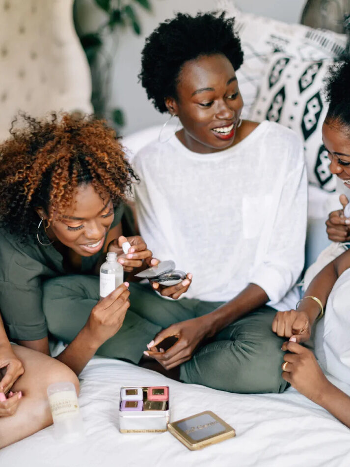 A group of women looking, touching, smelling a variety of BLK+GRN products. 