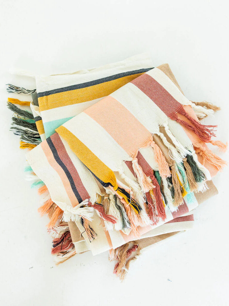 A folded colorful striped throw by Brightly.