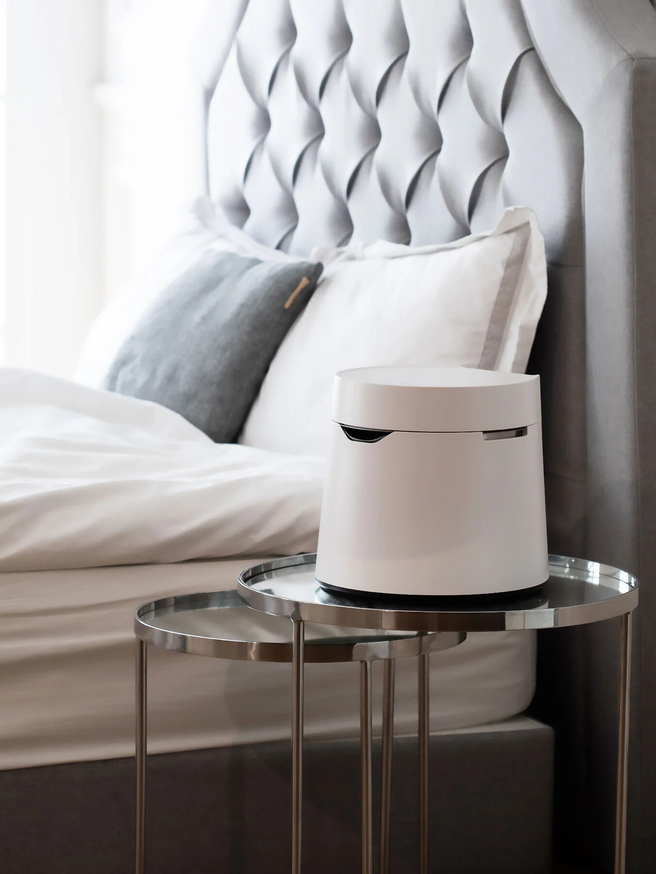A Carepod Humidifier next to a bed on a side table.