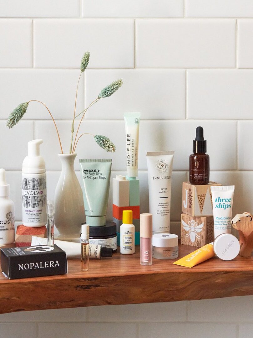 A variety of Credo beauty and skincare products on a wooden shelf. 