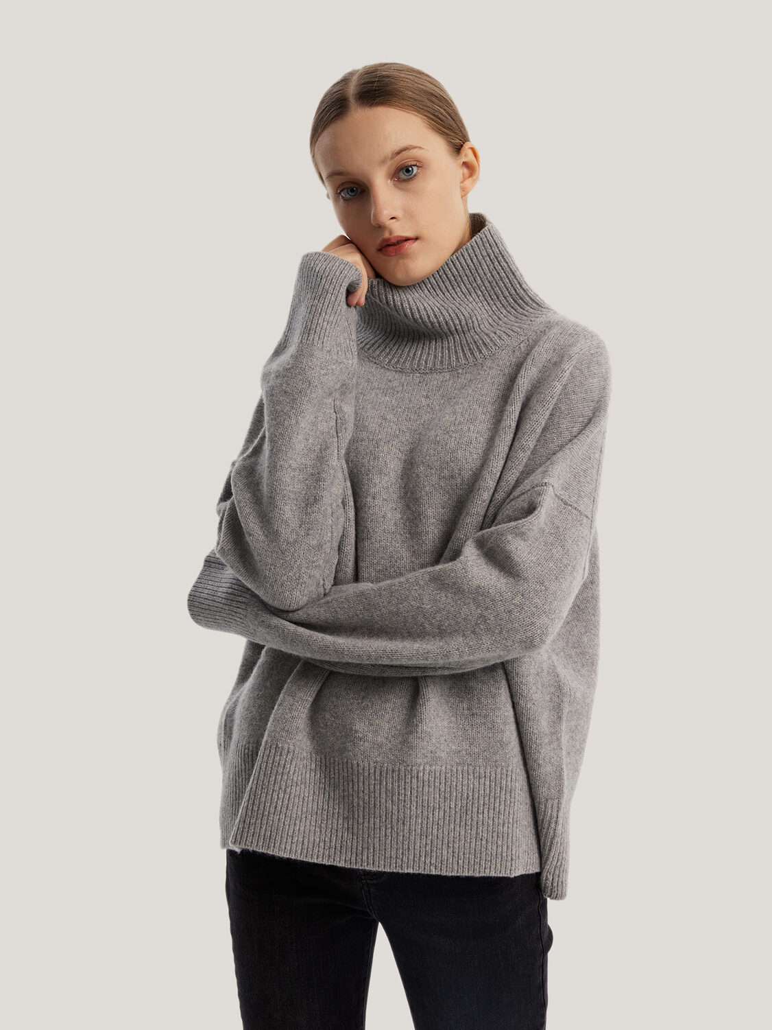 A model wearing a grey oversized cashmere sweater from Gentle Herd.