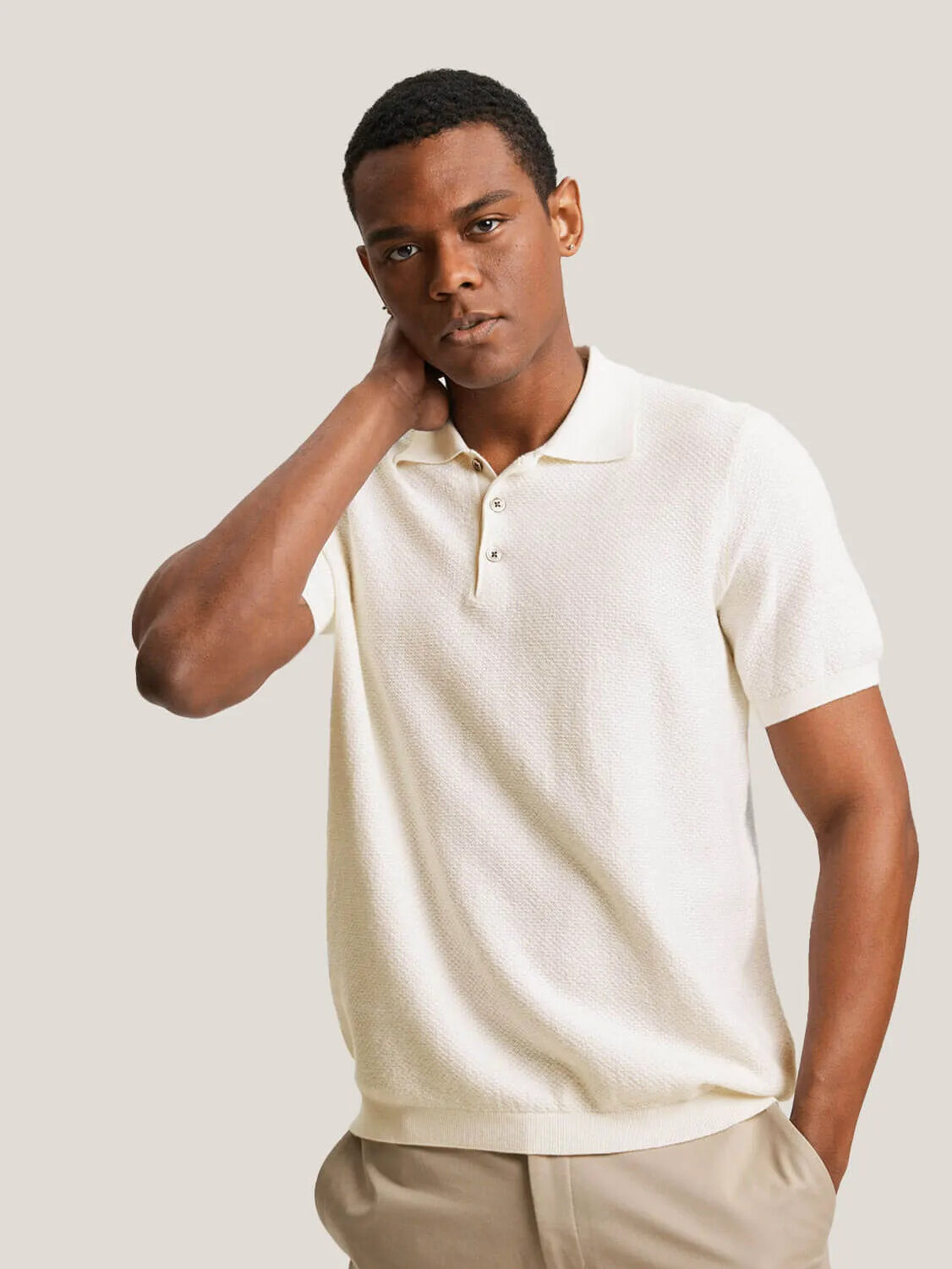 A model wearing a cream cashmere polo from Gentle Herd.