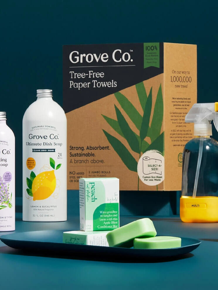 A variety of Grove Collaborative home cleaning products in front of a dark teal background. 