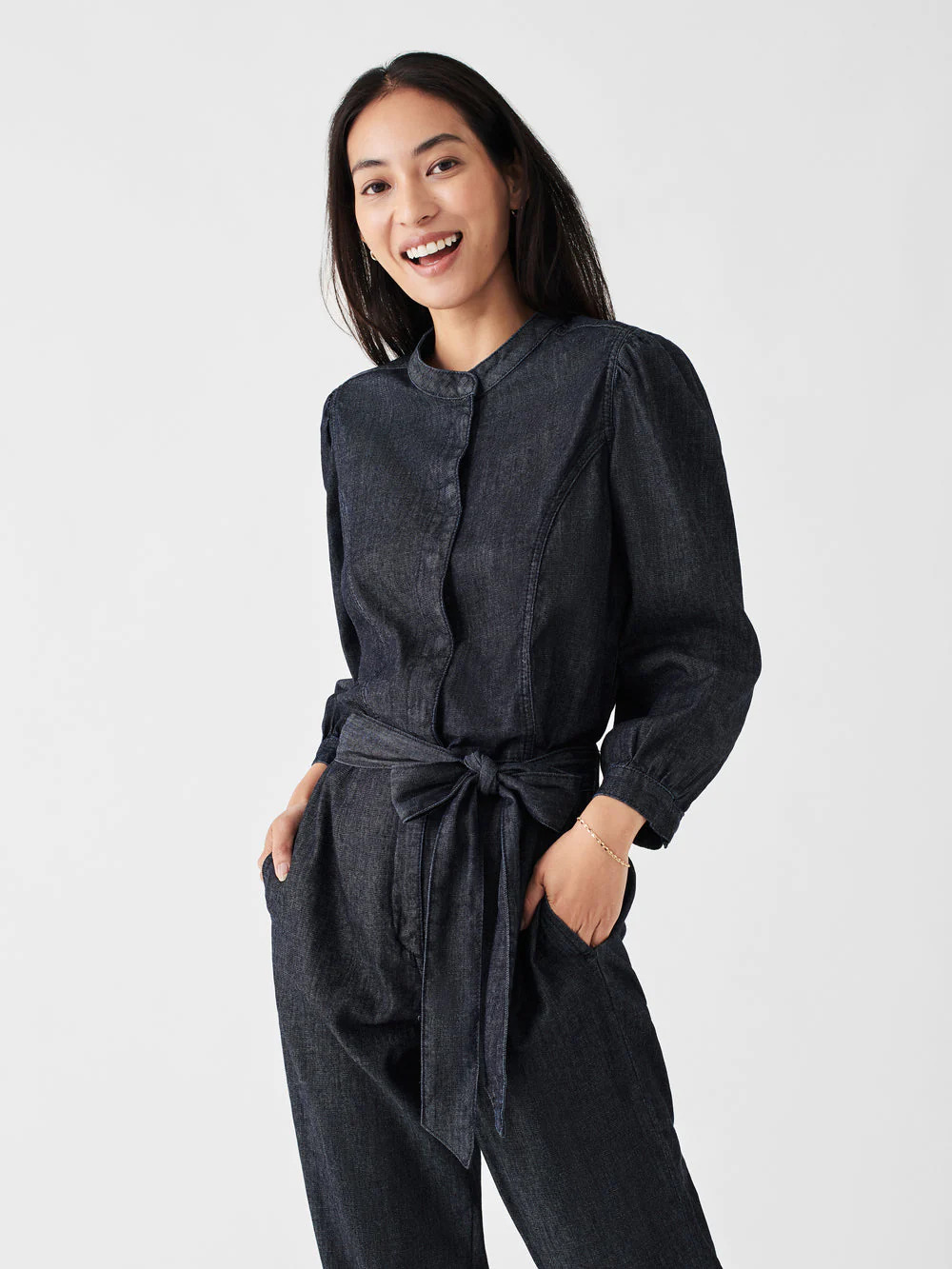 A model wearing a black button down denim jumpsuit from Haverdash.