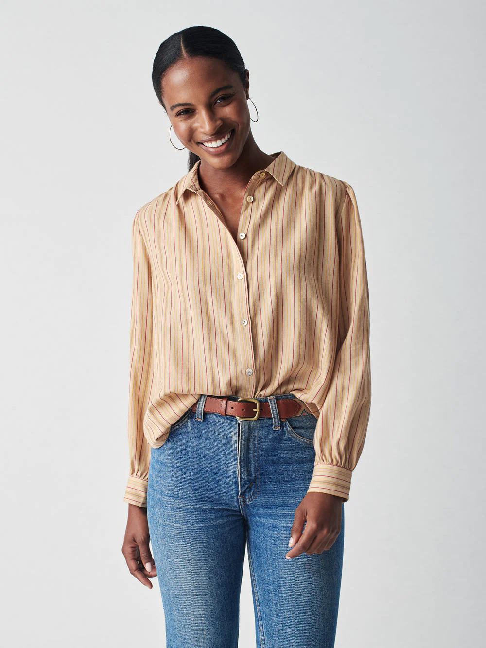 A model wearing a beige and brown striped button up collared long sleeve from Haverdash.