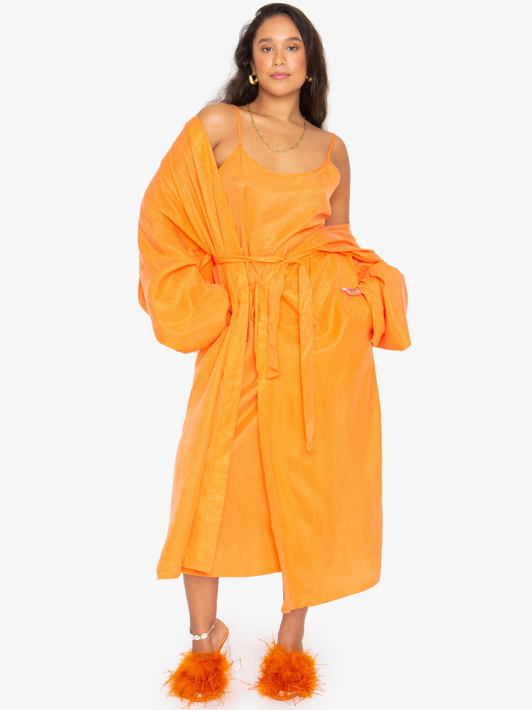 A model wearing Idle's long robe in tangerine.