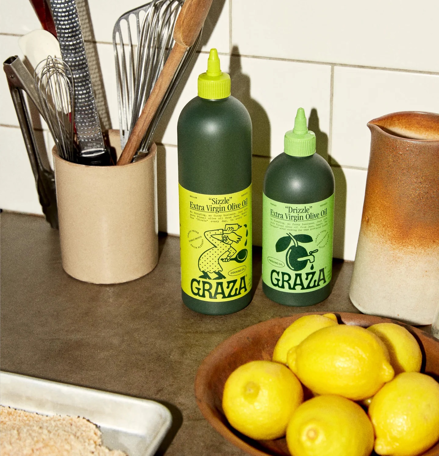 Two bottles of Graza olive oil on the counter.
