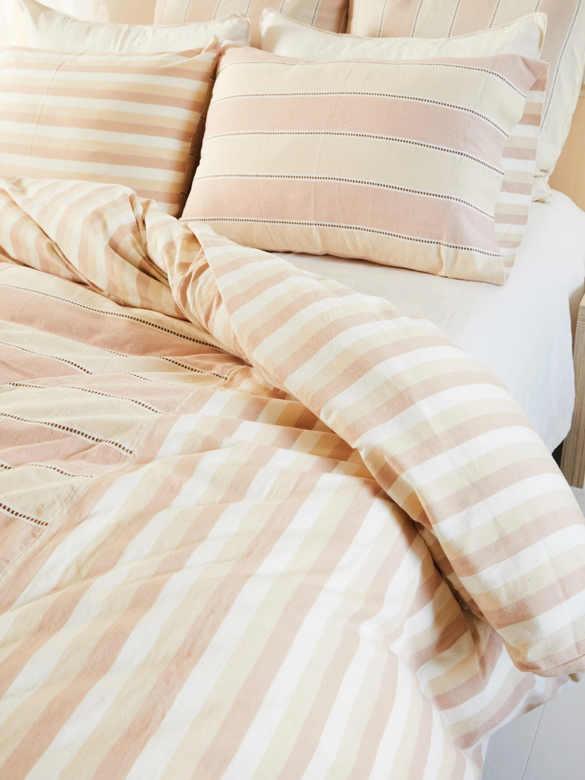 Salmon pink and pale yellow striped duvet and pillowcase by Minna. 