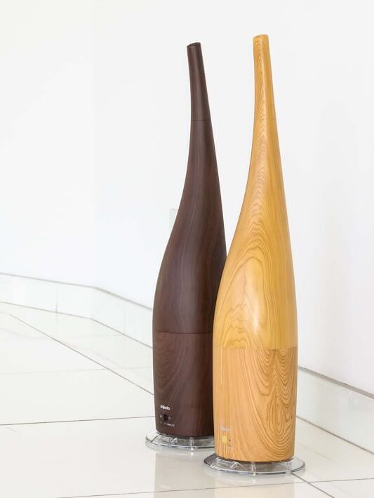 Two Objecto Humidifiers in light and dark wood finishes next to each other.