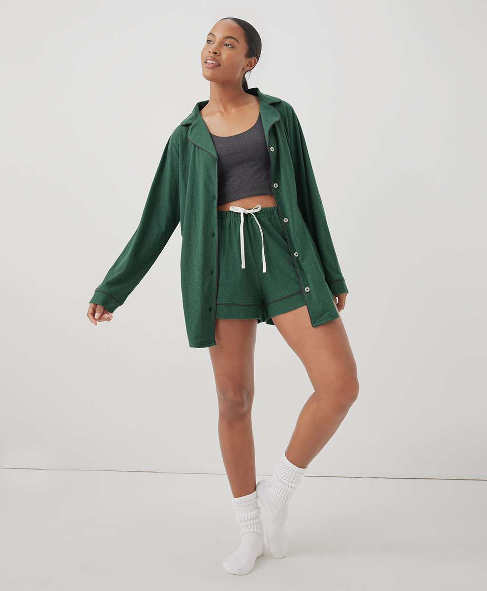A model wearing a green Pact pajama shorts set.