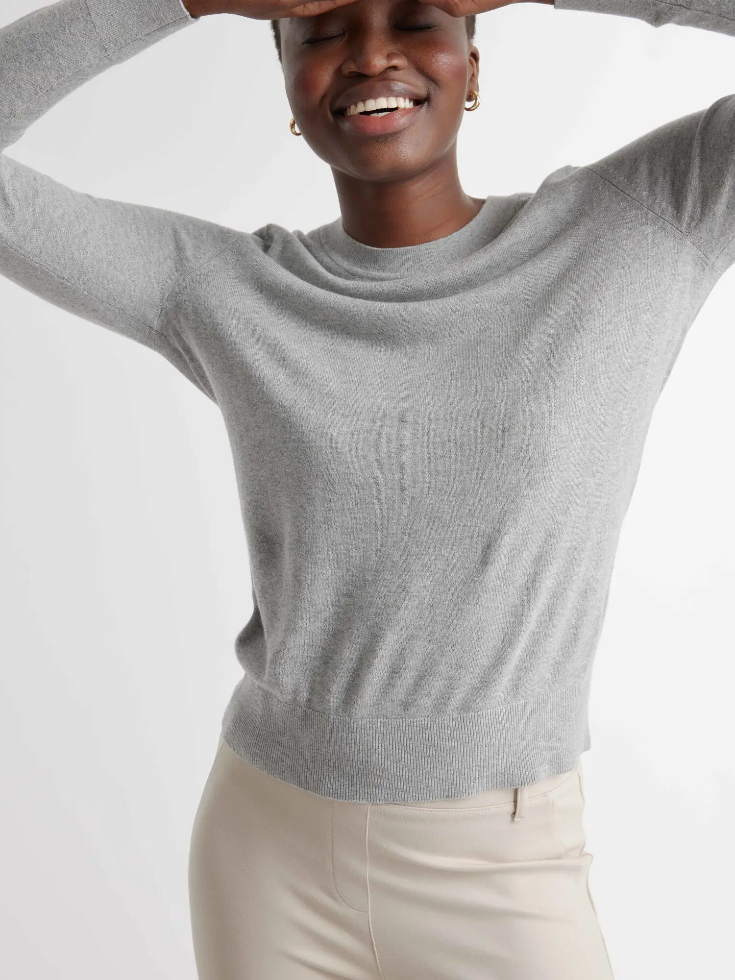A model wearing a grey Lightweight Cotton Cashmere Crew by Quince.