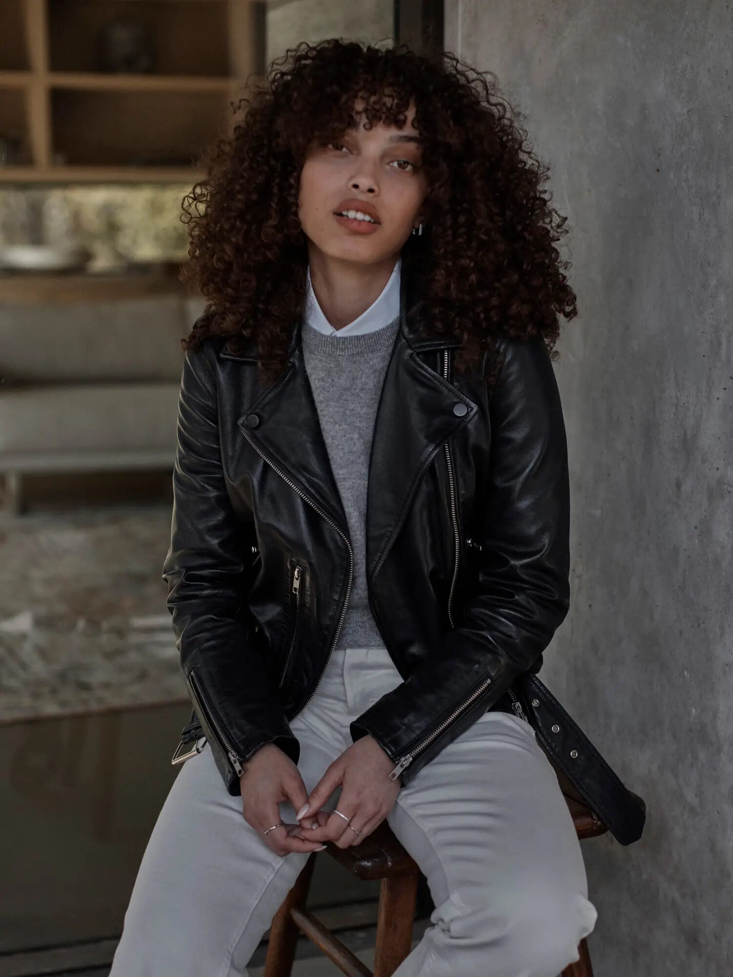 A model wearing a black leather jacket by Quince. 