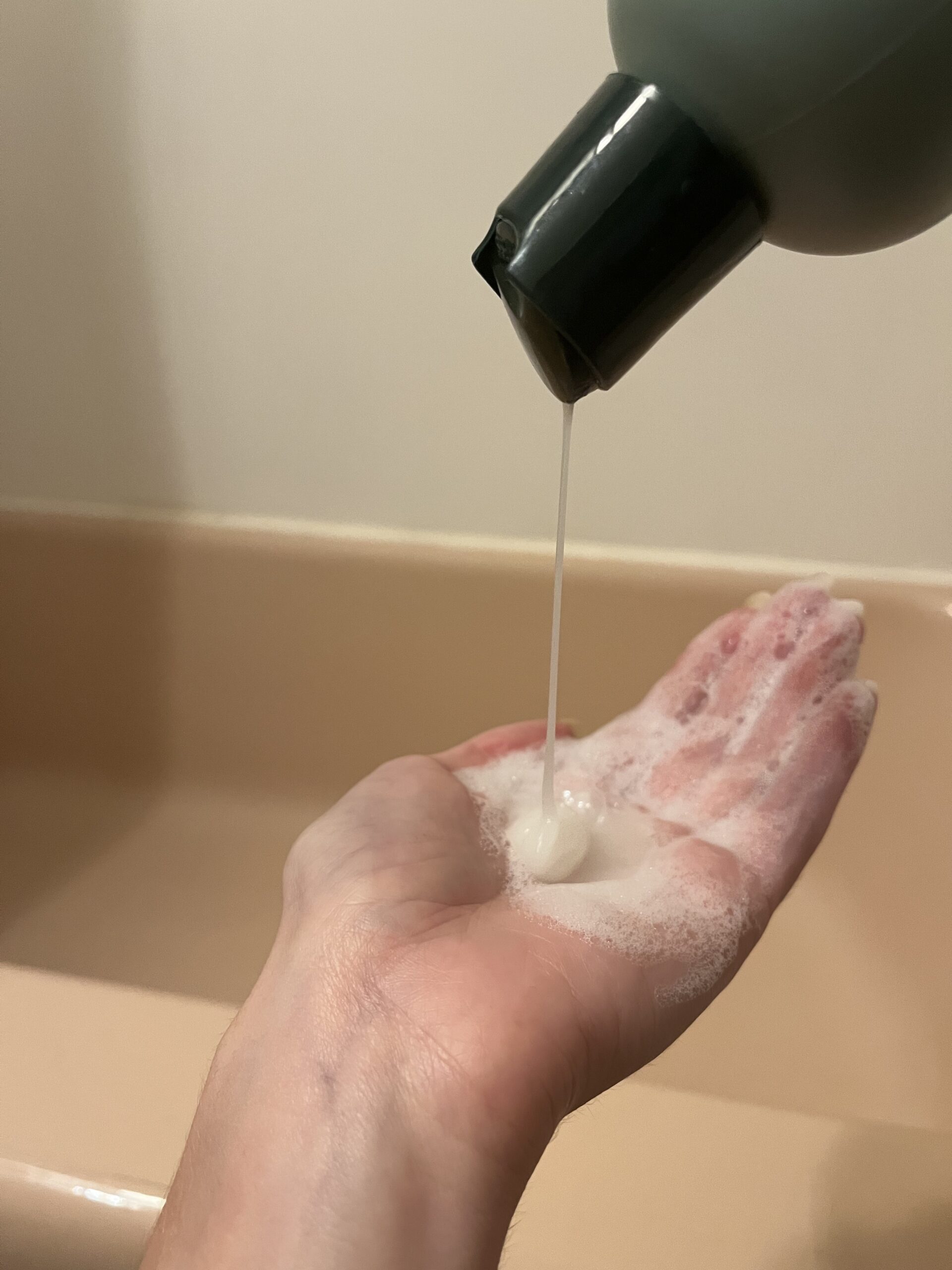 Sienna Naturals shampoo being poured into a hand. 