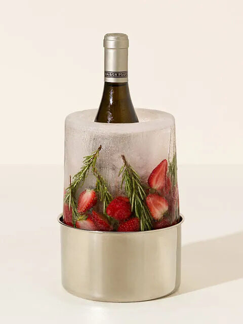 A wine/champagne aluminum chiller that looks like ice with strawberries and rosemary frozen into the ice. By Uncommon Goods. 